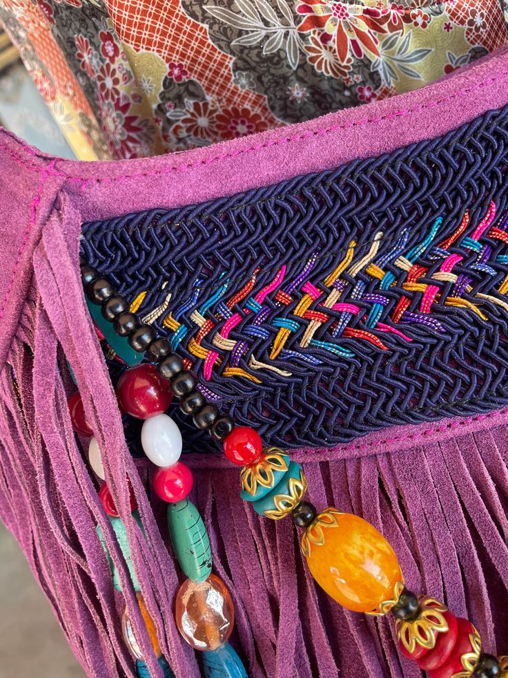 Orchid Leather Beaded Fringe Purse Each bag is unique and totally one of a kind! Room enough for all your daily essentials, this purse matches any bohemian style outfit and more. Featuring tassel and bead details, and so much fun fringe! Approx. 13" x 12" x 3" Zipper closure, 1 inside zipper pocket Bohemian Leather Bags As Fashion Accessory, Handmade Purple Bags For Festival, Bohemian Multicolor Handwoven Shoulder Bag, Bohemian Hand-stitched Bags, Handmade Hippie Shoulder Bag For Festival, Bohemian Festival Bags With Beaded Fringe, Hippie Handmade Festival Shoulder Bag, Hippie Handmade Shoulder Bag For Festival, Bohemian Beaded Shoulder Bag For The Beach