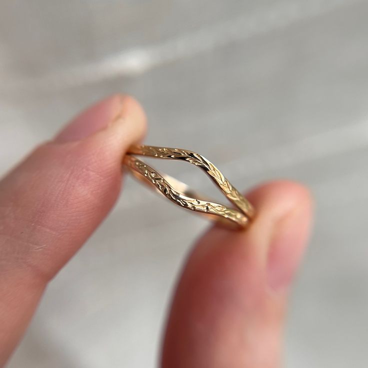 a person holding a gold ring in their hand