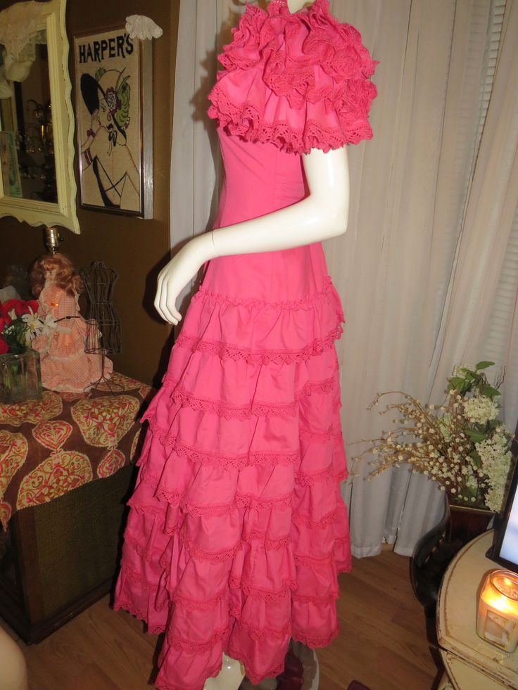 "Maybe 60's/70's lovely pink ruffle-listic dress, ankle-length, by Creaciones, in a size 7/C. Great Quinceanera celebration wear, with V-neck-off shouldered fitted bodice, huge ruffled 4 layered sleeves, and the skirt part is tapered at the waist, with and 8 layered ruffled skirt. The dress has a nylon back zipper closure, and in photo 6 & 7, is not zipped all the way to the top/back, because my mannequin is a slight too large for it. Dress is of cotton fabric, and is a little weighty from s Pink Floor-length Maxi Dress With Ruffle Hem, Pink Floor-length Dress With Ruffle Hem, Pink Ruffle Hem Maxi Dress For Wedding, Spring Party Vintage Dress With Ruffles, Spring Vintage Dress With Ruffles For Parties, Pink Fitted Maxi Dress With Ruffles, Fitted Pink Maxi Dress With Ruffles, Pink Maxi Dress With Ruffle Hem For Evening, Pink Vintage Dress For Summer Party