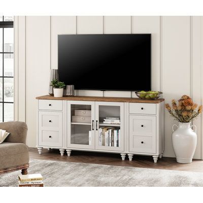 a living room with a large flat screen tv on top of a wooden entertainment center