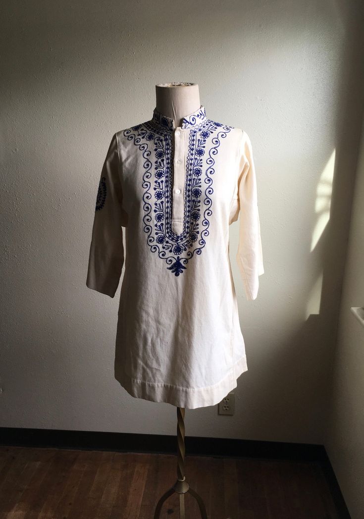 "1970s handmade embroidered tunic dress shirt cream with dark blue 3 button up neck side panels side slits (4 1/2\") nubby cotton w/light flecks light wear, good condition irregularities to fabric normal to artisan textiles no tags measures, flat, shoulder-14\" chest-20 sleeve-17 length-32" Spring Beige Cotton Kurta, Traditional Cream Cotton Blouse, Spring Cotton Kurta In Beige, Fitted Cream Kurta For Spring, Cream Bohemian Cotton Kurta, Fitted Cream Kurta For Summer, Traditional Beige Cotton Blouse, Bohemian Cotton Tunic With Resham Embroidery, Summer Long Sleeve Kurta With Yoke