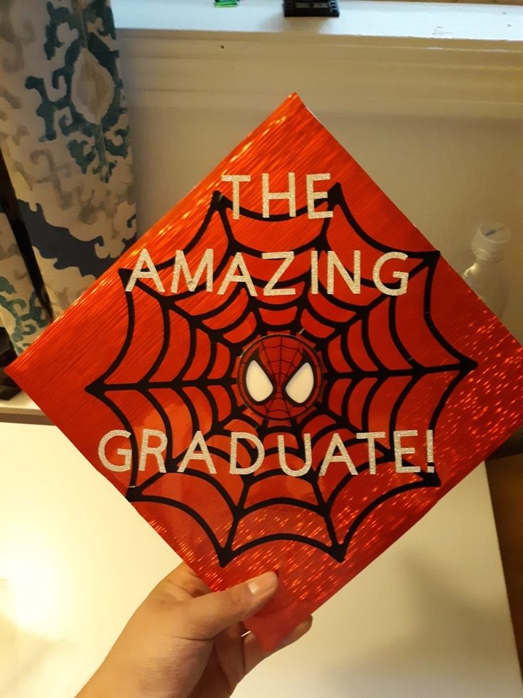 someone holding up a red graduation cap with the words, the amazing graduate