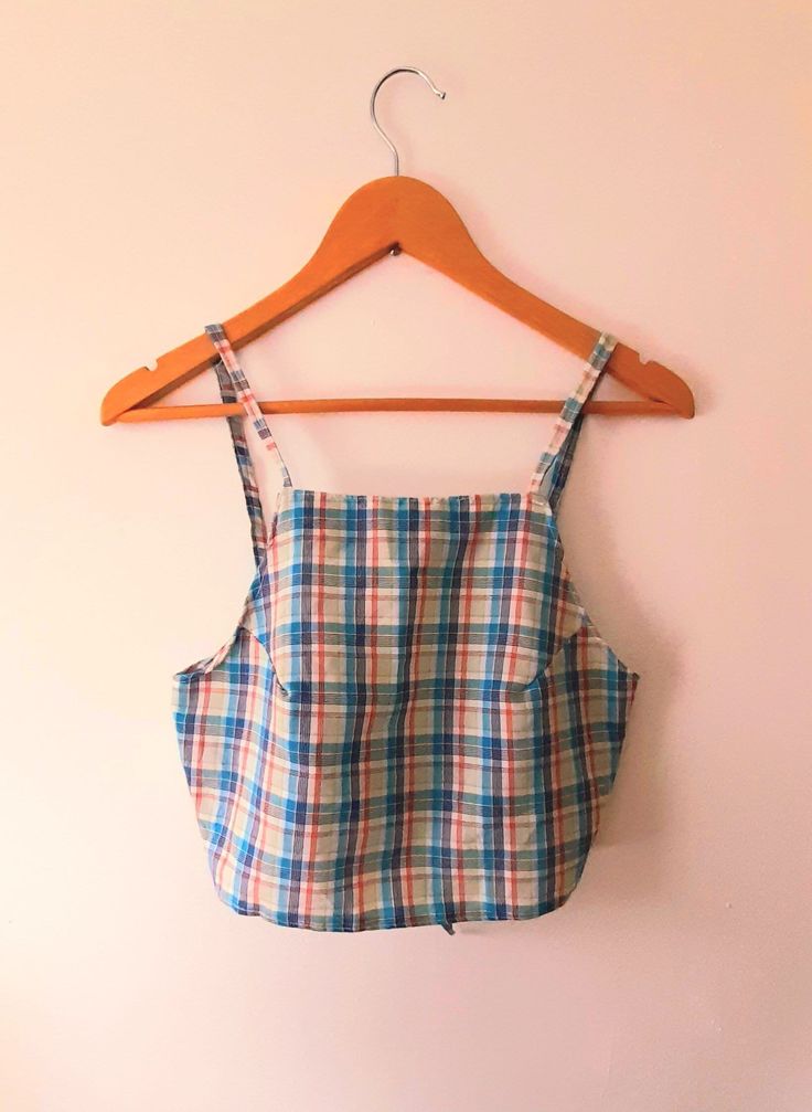 Vintage strappy summer top. Handsewn with amazing white, blue, green and red plaid cotton. Apron style with a high straight neckline, narrow shoulder straps and ties at the back. 🌾 🌤 MATERIAL Cotton SIZE M/L (UK 10/12) Flat measurements * Chest: As it ties at the back this can be adjusted. * Front length: 12" * Shoulder straps: 35cm long, 1cm wide Please don't hesitate to message any questions 👋 Cotton Sleeveless Tank Top For Picnic, Summer Cotton Tank Top With Square Neck, Summer Cotton Crop Top With Square Neck, Square Neck Cotton Tank Top For Summer, Summer Square Neck Top With Adjustable Straps, Gingham Cropped Cotton Top, Cropped Gingham Cotton Top, Sleeveless Plaid Tank Top For Summer, Sleeveless Plaid Top For Summer