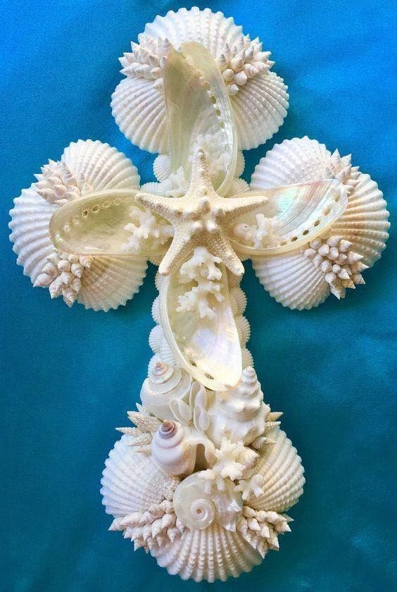 a cross made out of seashells on a blue background