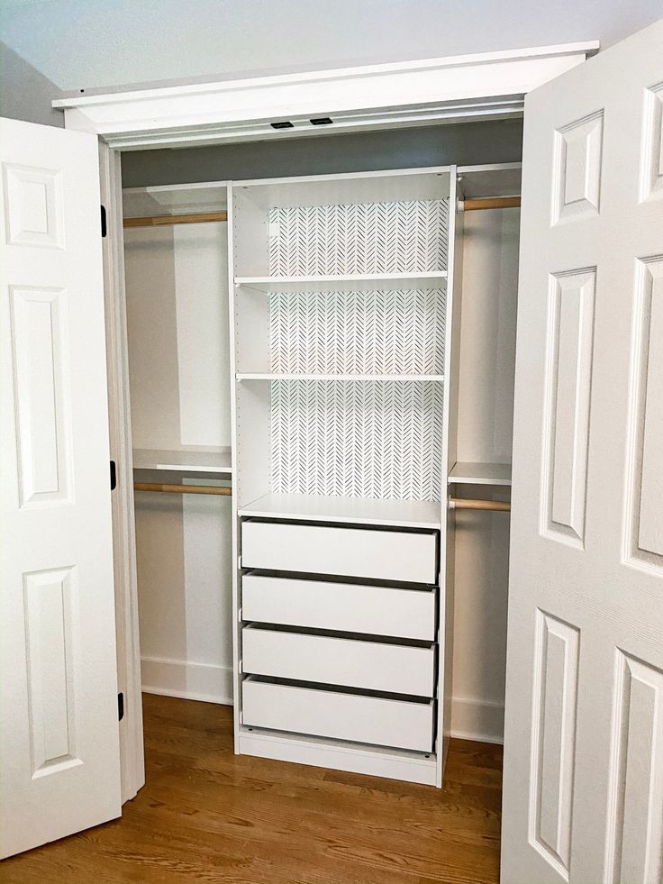 an empty white closet with drawers and shelves