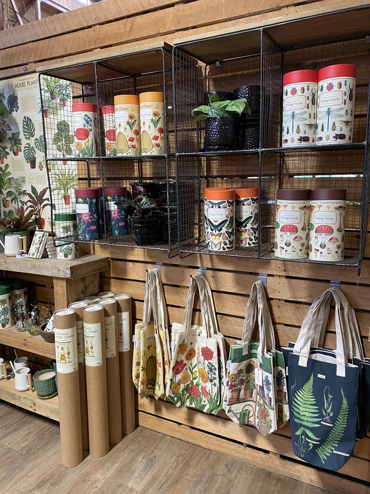 several bags are hanging on the wall in a shop with shelves full of plants and spices