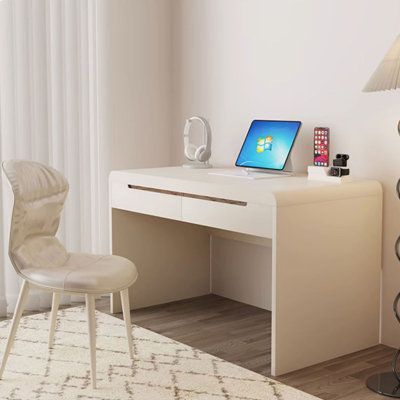 a white desk with a laptop computer on top of it next to a chair and lamp