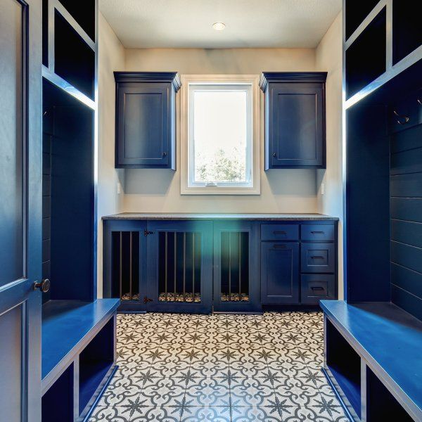 an empty room with blue cabinets and tile flooring on the walls, along with a window