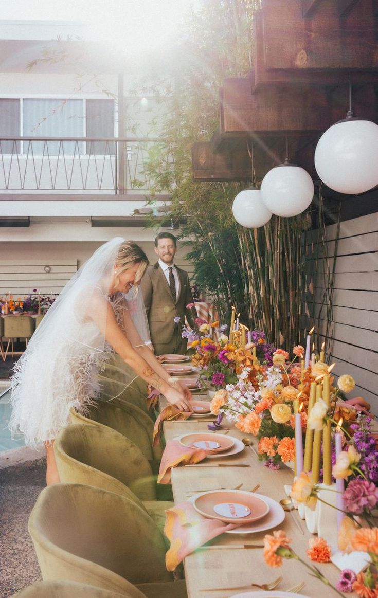 the bride and groom are cutting their wedding cake at the table with candles on it