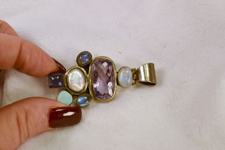 This gorgeous pendant is 925 silver, and set with a variety of semi-precious stones, including amethyst, pearl, opal and labradorite. It would look great on a man or woman, and would be a wonderful gift, even if its for yourself! This wonderful pendant will come to you in a gift box, ready for giving! Total weight on pendant is 24 grams, and it measures 2 1/2 inches by 1 1/4 inches. For more lovely vintage accessories, please visit: www.etsy.com/shop/CloesCloset?section_id=10559789 Elegant Multi-stone Healing Jewelry, Purple Multi-stone Pendant Gemstones, Amethyst Pendant Gemstones With Accents, Purple Multi-stone Pendant Jewelry, Multi-stone Amethyst For Jewelry Making, Multi-stone Pendant Gemstones For Jewelry Making, Multi-stone Amethyst Pendant Jewelry, Amethyst Multi-stone Pendant Jewelry, Artisan Gemstone Pendant With Accents