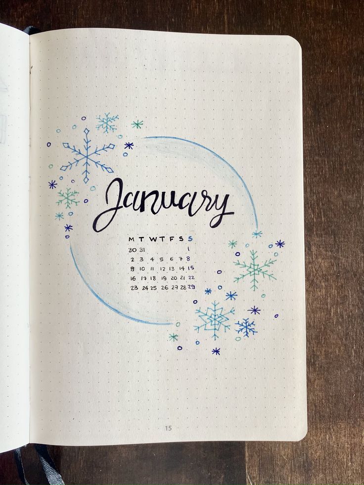 an open notebook with the word january written on it and snowflakes in the background