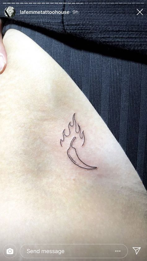 a small tattoo on the back of a woman's left arm, with a fire symbol