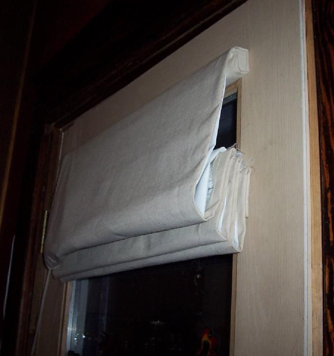 an open window with a white curtain hanging from it's side