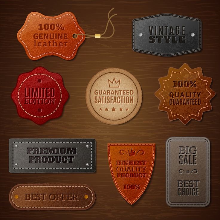 a set of leather badges and labels for different types of products on wooden background - miscellaneous objects