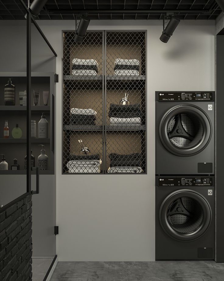 a washer and dryer in a room with black tile flooring on the walls