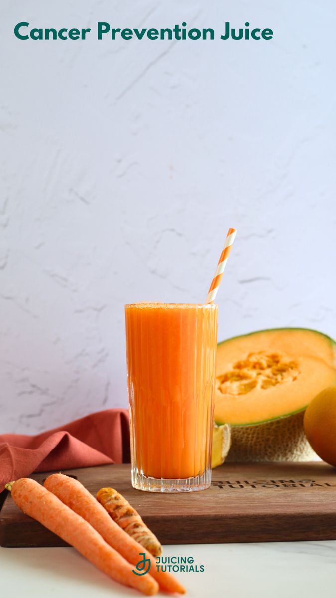 a glass filled with carrot juice next to sliced melon