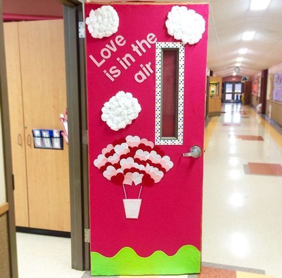 a pink door decorated with flowers and the words love is in the air