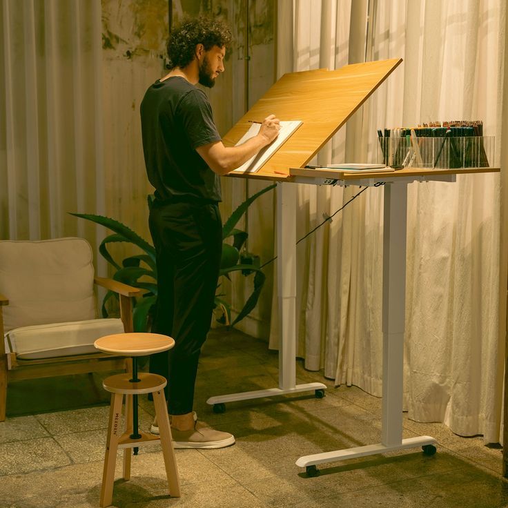 a man standing at a desk writing on a piece of paper