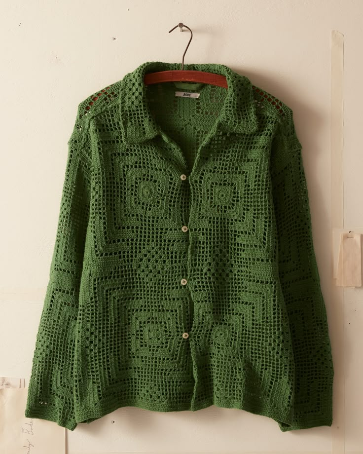 a green jacket hanging up on a wall