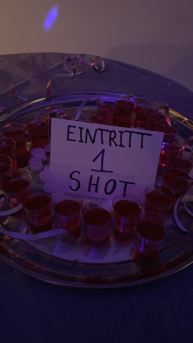 a sign that is sitting on a glass plate with cups in it and the words emitrit 4 shot