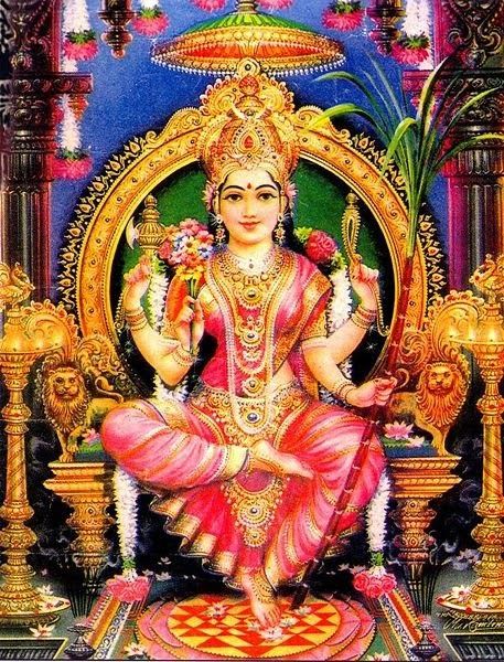 the hindu goddess sitting on a throne with flowers in her hand