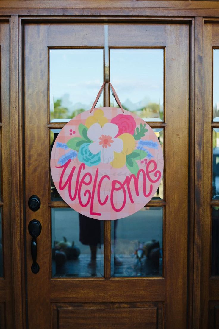 a welcome sign hangs on the front door