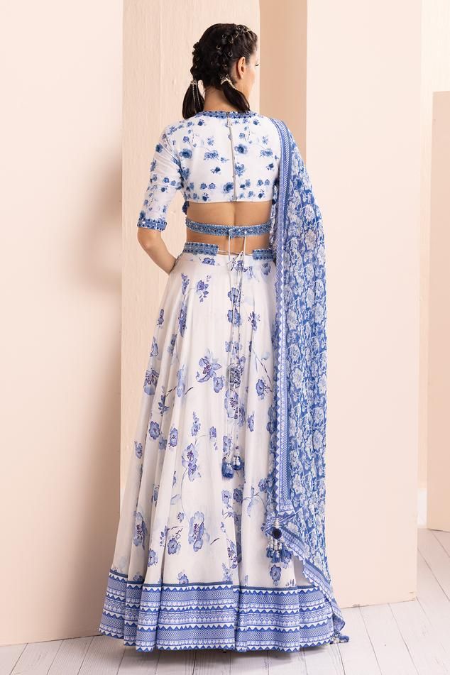 Periwinkle blue floral printed lehenga and geo blue geometric border. Comes with chanderi blouse with tonal embroidery, rectangular mirror work and 3D highlighted print and a georgette printed dupatta adorned with a chanderi border and ladder lace.
Components: 3
Pattern: Printed, Embroidered
Type Of Work: Floral
Neckline: V Neck
Sleeve Type: Short
Fabric: Chanderi, Georgette
Color: Blue
Other Details: 
Back tie-up blouse
Tassel edged dupatta
Closure: Blouse: Back zipper
Note: Belt worn by the mo Blue Anarkali Lehenga With Floral Print, Blue Fitted Anarkali Set With Floral Print, Fitted Blue Floral Anarkali Set, Traditional Blue Floral Print Lehenga, Traditional Blue Lehenga With Floral Print, Festive Blue Lehenga With Printed Motifs, Blue Bollywood Lehenga With Floral Print, Traditional Blue Lehenga With Printed Motifs, Anarkali Block Print Fitted Choli