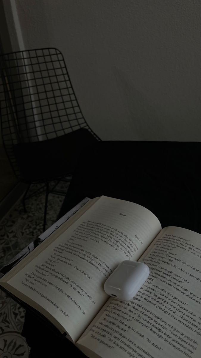 an open book sitting on top of a table next to a computer keyboard and mouse