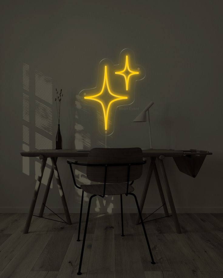 a table with two chairs and a yellow neon star on the wall above it in a dark room