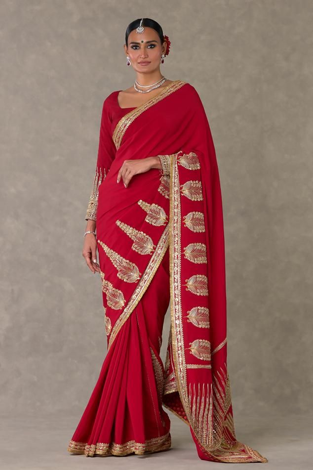 Red crepe silk saree with son patti, son chidiya and trikone embellishments using dori and sitara work. Comes along with an unstitched trikone embroidered blouse piece.
Components: 2
Pattern: Embellished
Type Of Work: Dori, Sitara, Son Patti, Son Chidiya
Fabric: Saree - Crepe silk, Blouse piece - Raw silk 
Color: Red
Other Details: 

Note:
The veil and salwar worn by the celebrity is not for sale
The stitched blouse worn by the model is not for sale
Disclaimer: The actual print-placement and col Masaba Saree Blouses, Red Semi-stitched Ceremonial Saree, Ceremonial Red Motifs Saree, Luxury Red Saree With Printed Border, Red Saree With Printed Border, Sitara Work, Crepe Silk Sarees, Red Saree, Print Placement