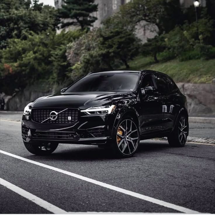 a black car is parked on the side of the road