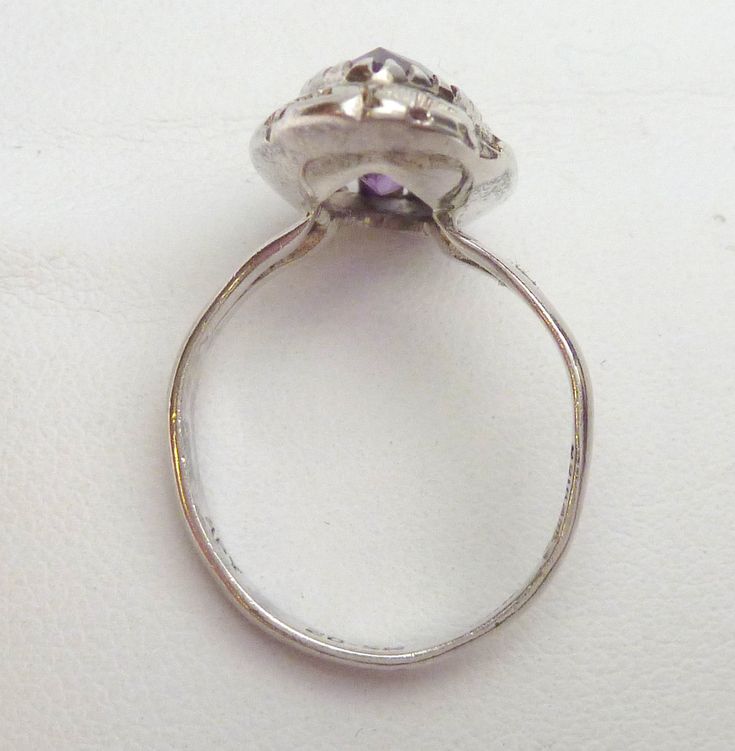 This is a really pretty ring that was so hard to photograph! Please know - the stone is not as bright purple as the photos show. Due to the color change optics of the stone, the camera can only show one color. The stone is actually a deeper purple with flashes of teal, and the stone will become more teal in different types of light. This ring features a marquise cut synthetic alexandrite that measures 15 x 7 mm. The stone is set in a bezel that is cut to look like lots of tiny prongs. The area a Vintage Purple Amethyst Ring For Anniversary, Vintage Amethyst Crystal Ring With Gemstone Detail, Vintage Amethyst Crystal Ring With Gemstone, Vintage Amethyst Cabochon Ring As Gift, Vintage Oval Birthstone Ring Collectible, Vintage Oval Birthstone Ring As A Collectible, Vintage Cabochon Amethyst Ring Gift, Vintage Cabochon Ring For Promise, Vintage Purple Crystal Round Ring