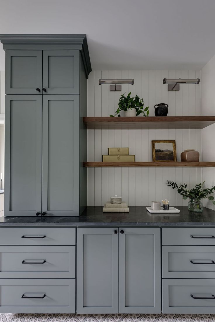 a kitchen with gray cabinets and white walls