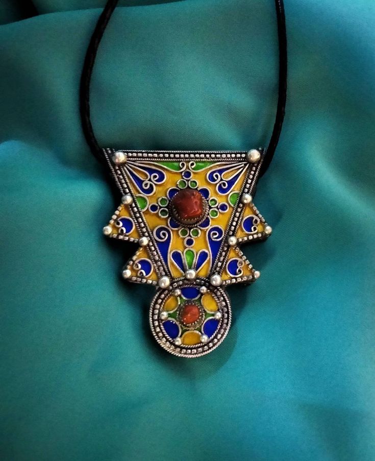 Ancient Berber talisman (herz) in sterling silver, enamelled in blue, green and yellow color. and decorated with a real coral cabochon. Height: 7 cm. Width: 5.5 cm. Leather: 54 cm. ++Material: sterling silver 925, real coral cabochon. ++Weight: 31.8 grams. ++ Origin: Morocco 1970s. Free worldwide shipping by DHL. I am always open to offers for one of my items, so please contact me if you would like to make an offer. Don't hesitate to contact me for any questions. All items advertised for sale ar Handmade Rituals Pendant Jewelry, Artisan Medallion Jewelry For Festivals, Amulet Pendant Jewelry For Rituals, Unique Ceremonial Jewelry With Large Pendant, Large Pendant Jewelry For Festival, Ritual Amulet Pendant Jewelry, Handmade Medallion Amulet Jewelry, Artisan Jewelry With Large Pendant For Festivals, Artisan Pendant Jewelry For Ceremonial Occasions