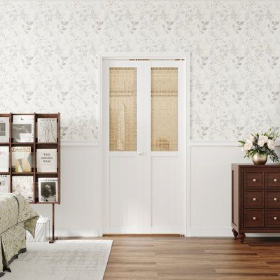 a living room with white walls and wooden flooring next to a brown chest of drawers