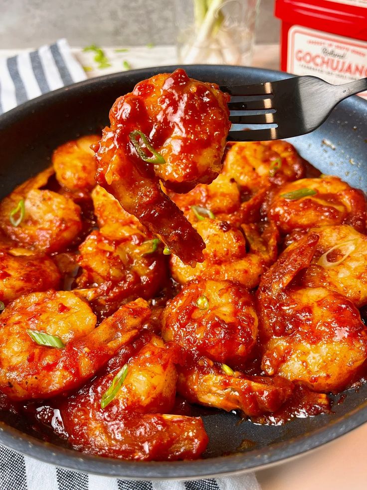 a skillet filled with chicken wings and sauce