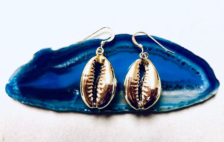 Beautiful Real Cowrie Shell Earrings Dipped in 24 kt Gold with 14 kt gold filled Ear wires, which are great for sensitive ears. * What is gold filled? It is a very specialized process which involves fusing a layer of solid 14 kt Gold to brass through high heat and pressure. The bond that is created is a permanent one. The outer layer is solid gold and it is for this reason, 14 kt gold filled will wear like real gold and will remain bright and shiny. These stunning earrings come with rubber backi Beachy Jewelry Boho, Cowrie Shell Earrings, Libra Necklace, Beachy Jewelry, Butterfly Earrings Gold, Earrings Summer, Zodiac Jewelry, Zodiac Necklaces, Gold Necklace Layered