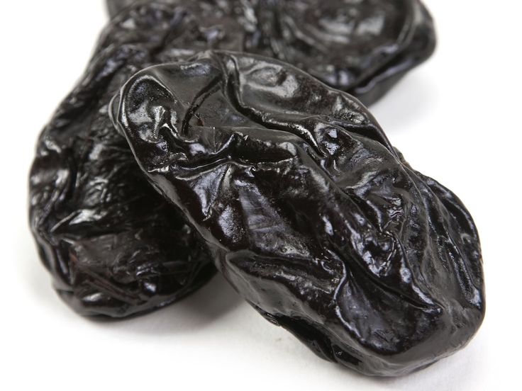 three black raisins on a white background with clipping for the top one