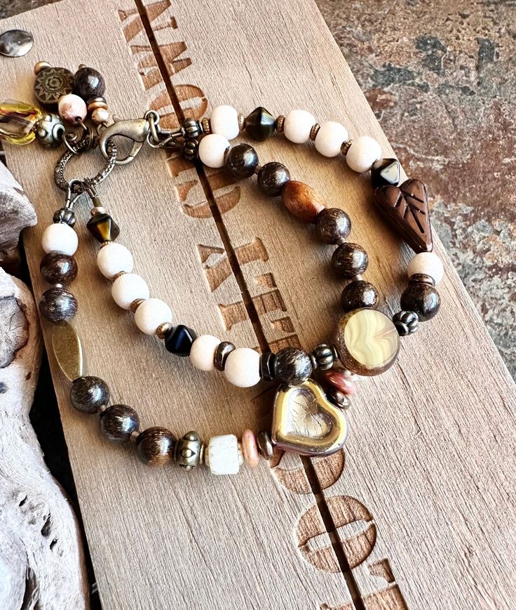 This is one of my favs! The rustic boho look with natural wood beads and bronzite stones, with love love czech glass hearts and bronze accents. Just beautiful colors! Quality gift idea or something special for yourself. If there are ANY issues with my artistry or product, I will honor my work Details:  Czech glass metallic heart - one side has a copper affect and the other side is a gold affect Czech glass heart - glossy bronze elongated  Czech glass stain glass "look" copper wash edges and sage Bohemian Wrap Bracelet For Layering, Rustic Wooden Beads Bracelet, Hand Wrapped Bronze Bohemian Bracelet, Rustic Brown Hand Wrapped Beaded Bracelets, Rustic Brown Hand-wrapped Beaded Bracelets, Bohemian Multi-strand Brown Bracelet, Bohemian Brown Multi-strand Bracelets, Bohemian Bracelets For Layering, Bohemian Beaded Bracelets With Natural Stones For Layering