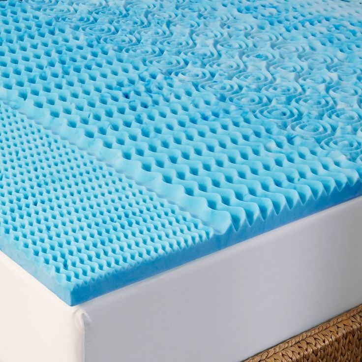 a close up view of a mattress with blue foam on it and wicker bed frame