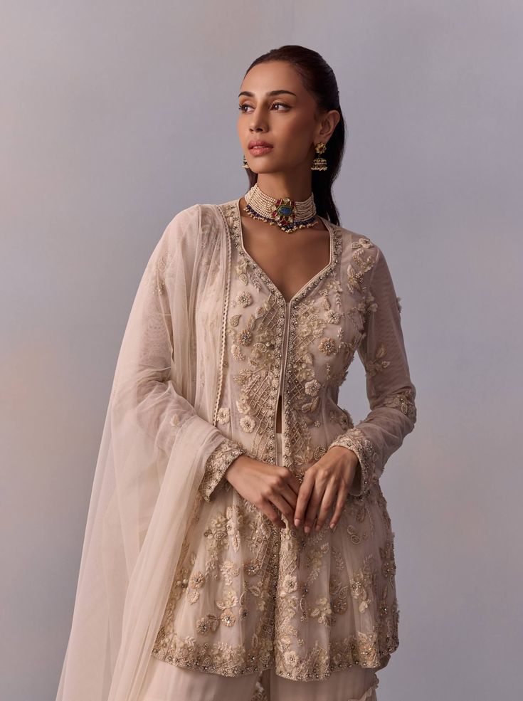 Dazzle in the elegance of the Mariam gharara set, featuring a regal ethnic design adorned with intricate hand embroidery on the jacket, enhanced with beads and sequins. Paired with a layered sharara and a coordinated dupatta, this ensemble creates a stylish look perfect for festive celebrations and wedding occasions. Layered Sharara, White Sharara, Ethnic Design, Sharara Set, Modern Woman, Hand Embroidery, Off White, Festival, Couture