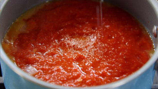 the sauce is being poured into the pot