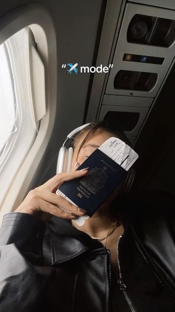 a woman reading a book while sitting on an airplane seat with her head resting on a passport