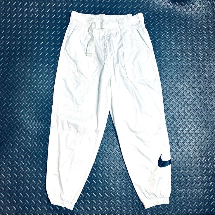 Brand: Nike Women’s ( I Personally Bought From The Nike Store In La Super Stylish Just Never Wore ) Style Type: Track Pants ( Loose Fit ) Size: Large ( Please See Measurements If Needed Full Length <- ( Please See Measurements If Needed High Waisted ( Please See Measurements ) Adjustable Belt Pockets Material: 100% Nylon- Pockets / 100% Polyester Pants Color: White ( A Bit See Through ) Condition: New Condition! ( I Also Have These In Black As Well ) - Please Feel Free To Check Out My Page For Other Great Finds! :) - Same Day Or Next Day Shipping! Mon-Sat. ( No Shipping On Holidays - Smoke Free / Pet Free - Great Packagi High Waist White Cargo Pants For Streetwear, White High Waist Cargo Pants For Streetwear, High Waist White Pants For Streetwear, White High Waist Pants For Streetwear, White Cargo Pants With Elastic Waistband For Streetwear, White High-waist Bottoms For Streetwear, White High Waist Bottoms For Streetwear, White Parachute Pants For Spring Streetwear, White Cargo Pants With Elastic Waistband For Spring