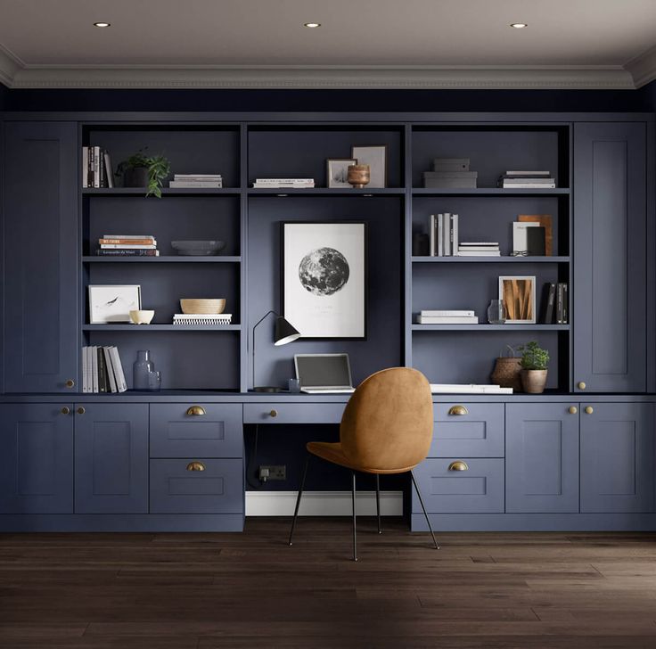 a chair sitting in front of a desk with bookshelves and shelves on it