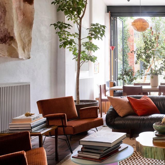 a living room filled with lots of furniture and a tree in the middle of it