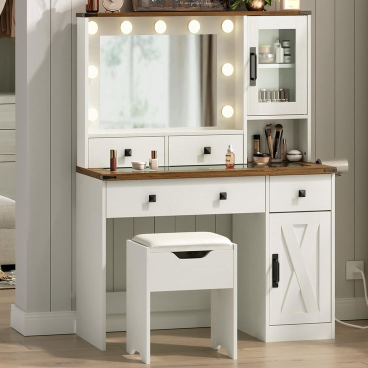 a white vanity with lights on it and a stool in front of the counter top