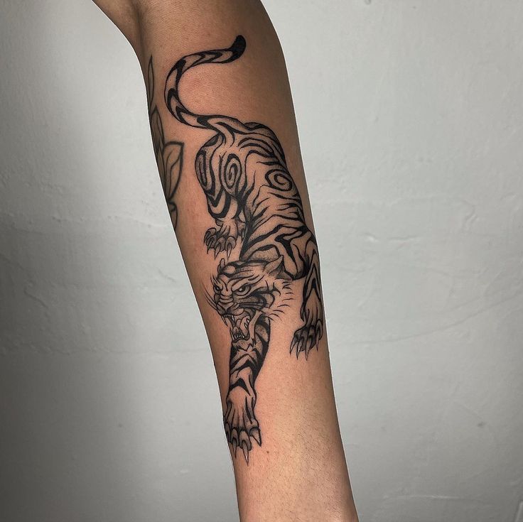 a black and white tiger tattoo on the arm