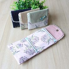 three pieces of cloth sitting on top of a wooden table next to a potted plant