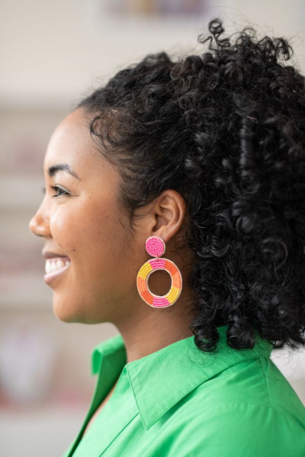 Our Oglethorpe hoop earring in pink, yellow, and orange is the perfect pop of color to spice up any outfit! All of our earrings are lightweight and hypoallergenic. Earring measures: 2.5 in. L x 1.75 in. W. Each earring features soft, acrylic felt backing. Designed in our Creative Studio in Charleston, SC & handmade by skilled artisans. Due to the handmade nature of our beaded styles, each may vary. This listing is for one item. Trendy Orange Jewelry For Spring, Yellow Hoop Earrings For Spring, Orange Small Hoop Earrings For Summer, Spring Multicolor Beaded Earrings, Summer Orange Small Hoop Earrings, Spring Pink Fun Jewelry, Pink Fun Spring Jewelry, Fun Pink Spring Jewelry, Pink Hoop Beaded Earrings